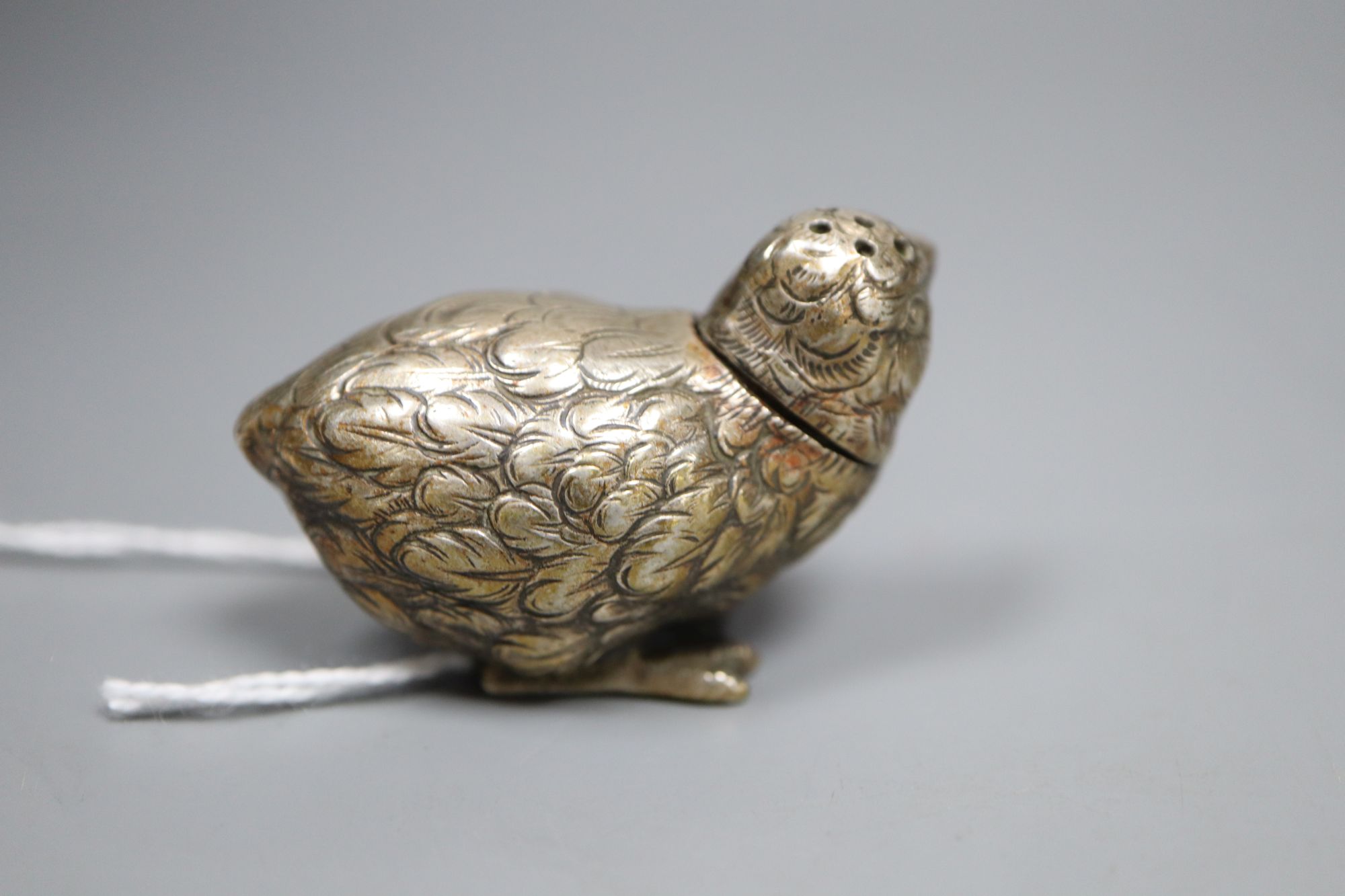 An Edwardian white metal chick pepperette or vinaigrette, with removable head, unmarked, 4.5cm